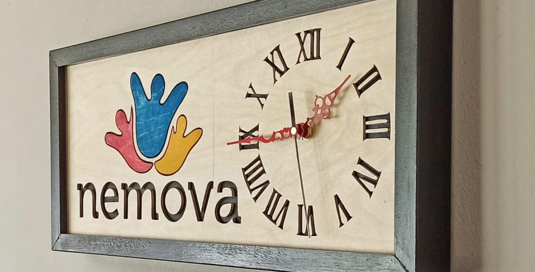 Seinäkello, johon kaiverrettu Nemovan logo